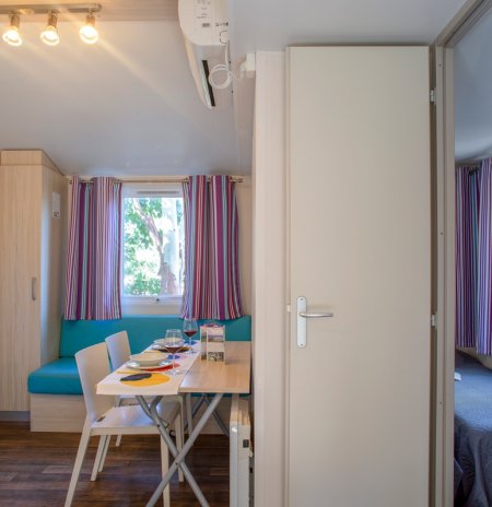 Interno con tavolo, sedie e divano colorato.