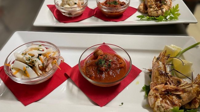 Piatti rettangolari con antipasti di mare.