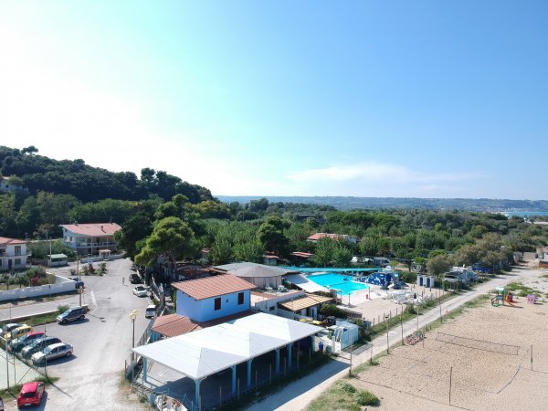 Vista aerea di un complesso con case, piscina e verde attorno.