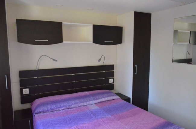Camera da letto con letto matrimoniale e armadi scuri.