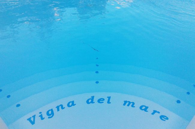 Gradini bianchi di una piscina con scritta 