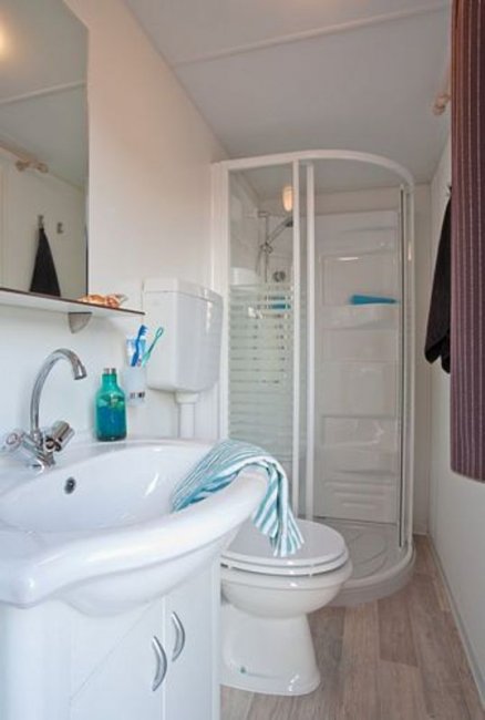 Bagno con doccia, lavandino e wc, ben illuminato e moderno.