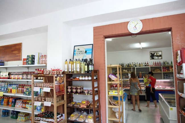 Un piccolo negozio con scaffali pieni di alimenti e bevande.