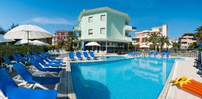 Piscina all'aperto con lettini blu e ombrelloni vicino a edifici residenziali.
