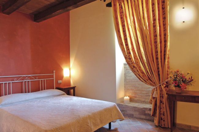 Camera da letto con tenda a righe e illuminazione calda.