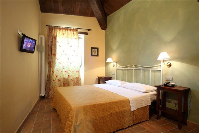Camera da letto con letto matrimoniale e parete verde chiaro.