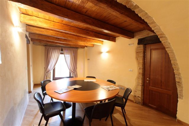 Sala con tavolo rotondo e travi in legno.