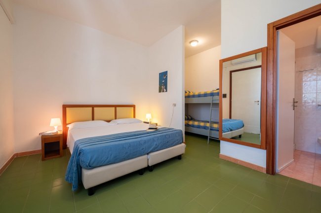 Camera da letto con letto matrimoniale e letti a castello.
