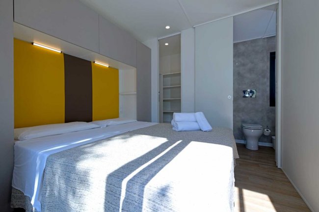 Camera luminosa con letto matrimoniale e bagno.
