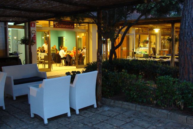 Tavoli all'aperto di un ristorante con persone sedute.