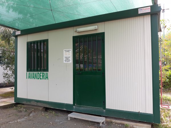 Struttura lavanderia con pareti bianche e porta verde.