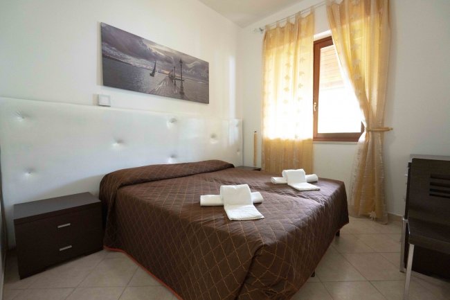 Camera da letto con letto matrimoniale e asciugamani.