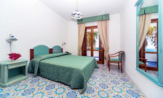 Camera con letto matrimoniale e decorazioni verdi.