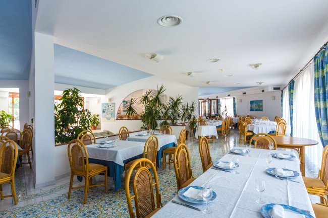 Ristorante luminoso con tavoli apparecchiati.