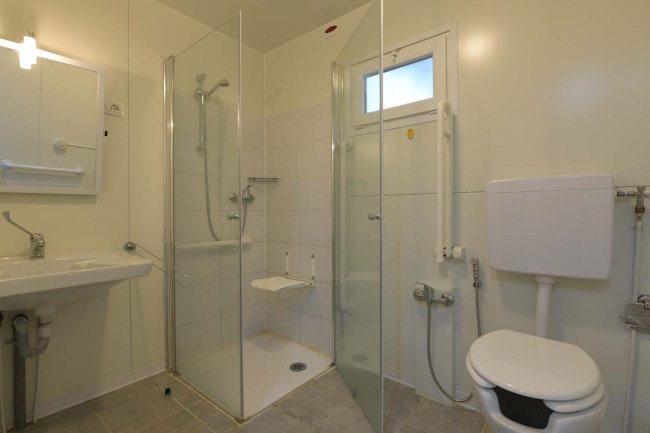 Bagno moderno con doccia vetrata e wc.