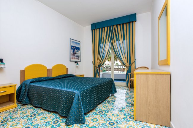 Camera con letto matrimoniale, arredamento giallo e blu.