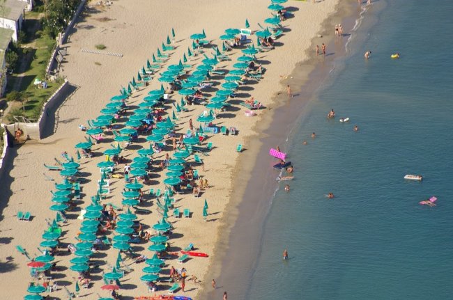 Spiaggia con ombrelloni e bagnanti.