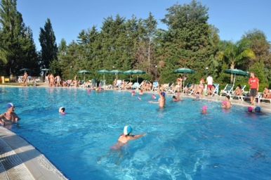 Piscina all'aperto con persone che nuotano.