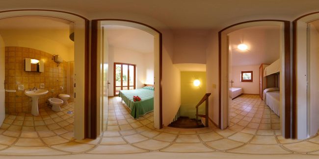 Interno di appartamento con bagno, camera con letto matrimoniale e cameretta con letti a castello.