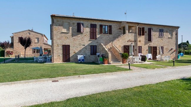 Edificio in mattoni con giardino e sedie.