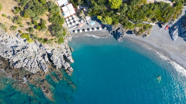 Vista aerea di una spiaggia e acqua blu.