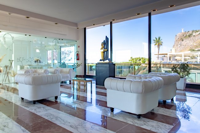 Sala con divani bianchi e ampie vetrate.
