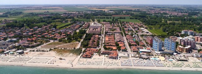 Vista dall'alto di un quartiere urbano vicino a una lunga spiaggia.