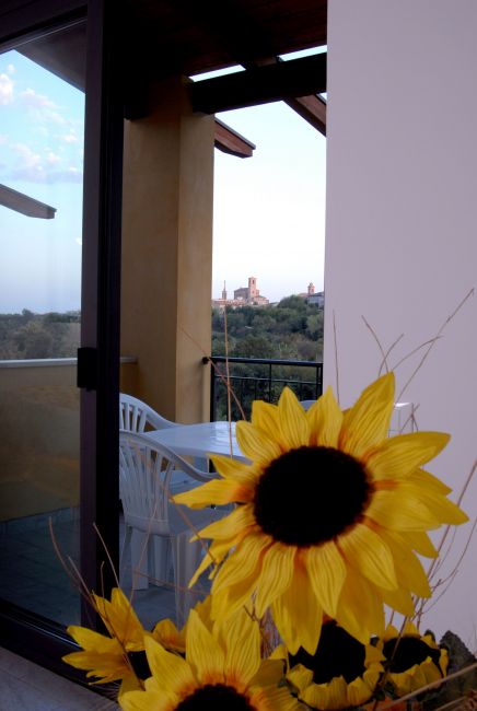 Fiore di girasole con balcone e vista sulla città in lontananza.