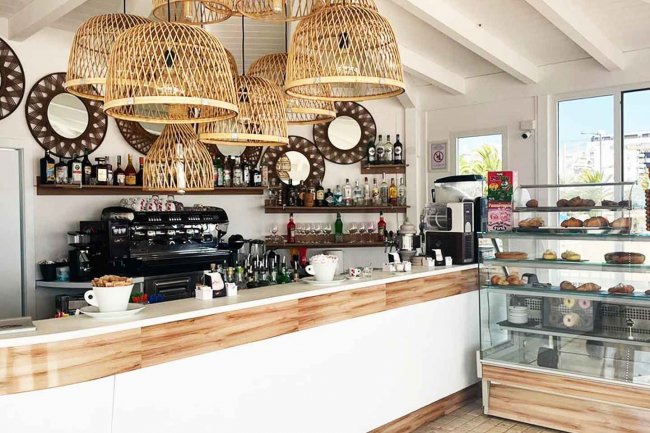 Un bar moderno con cesti di bambù e vetrina di dolci.