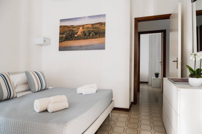 Camera da letto moderna con un letto matrimoniale e asciugamani piegati.