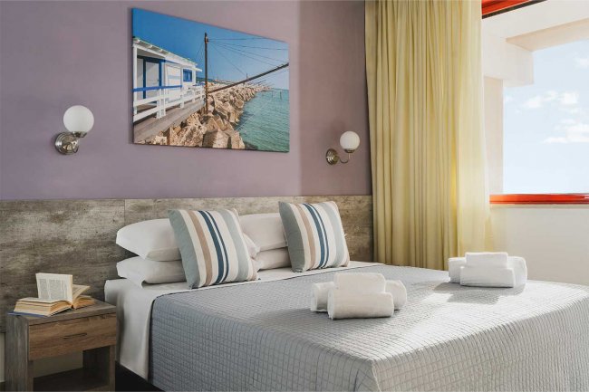 Camera con letto matrimoniale e decorazione marina.