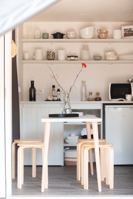 Tavolo bianco con sedie in legno chiaro in una cucina moderna e minimalista.