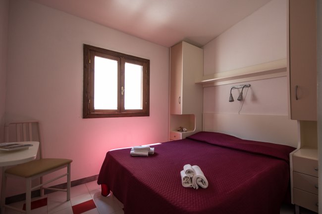 Camera con letto matrimoniale e finestre.