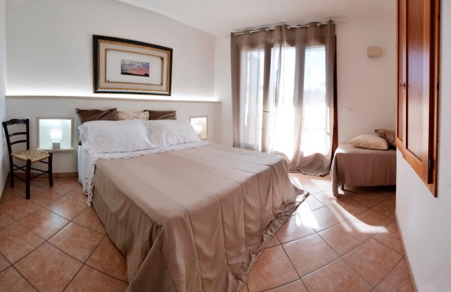 Camera da letto luminosa con letto matrimoniale e finestra.