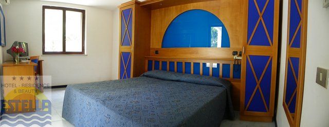 Una camera d'hotel con letto matrimoniale, decorazioni blu e mobili in legno.
