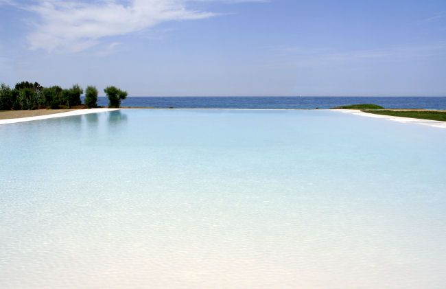 Piscina a sfioro con vista sull'oceano e cielo azzurro.