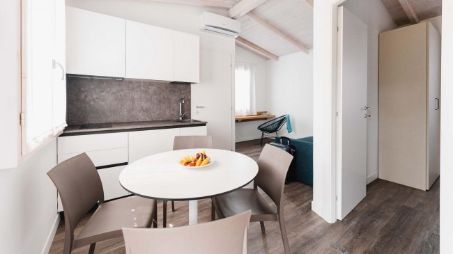 Cucina moderna con tavolo rotondo e quattro sedie.