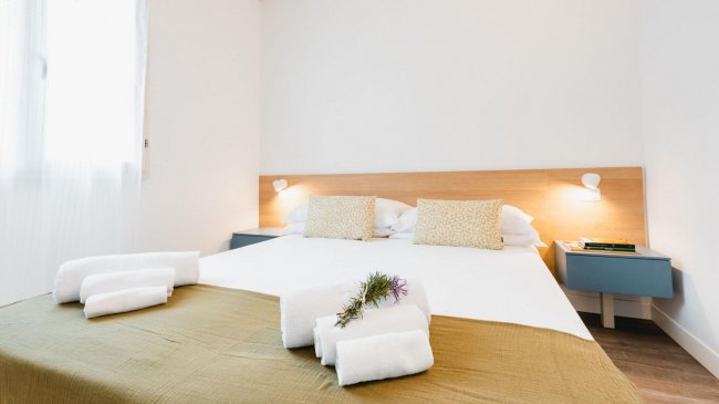 Camera da letto con letto matrimoniale e asciugamani piegati.
