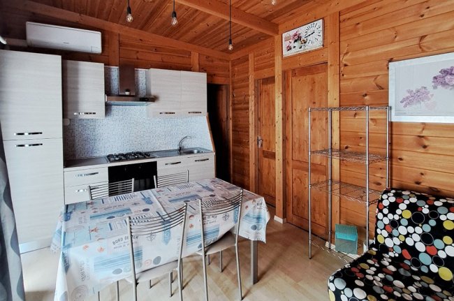 Cucina in legno con tavolo apparecchiato e sedie.