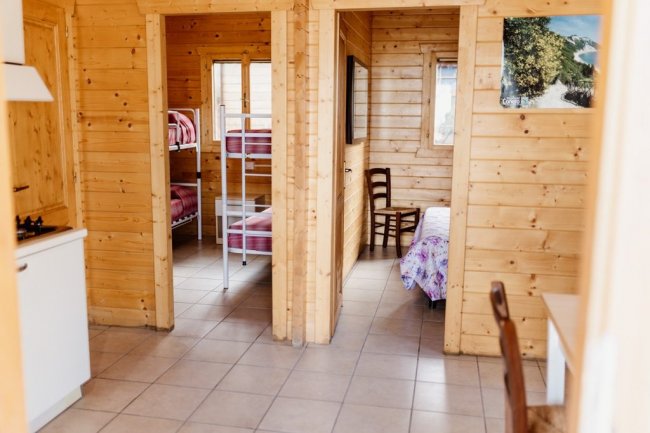 Interno con cucina, letti a castello e un letto singolo.